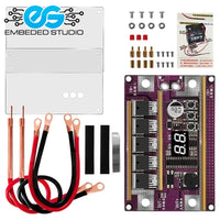 An electronics DIY kit featuring a purple 12V spot welder control module with a digital display, accompanied by a white metal enclosure plate, copper welding pens, wiring, and mounting hardware.