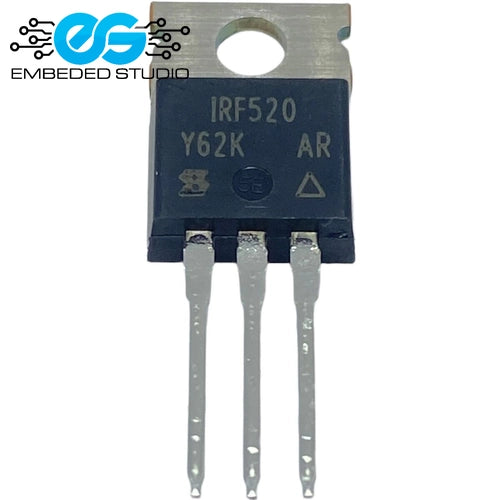 An IRF520 Y62K power MOSFET transistor with a dark blue/black body, silver metal heatsink tab, and three long silver leads, shown on a white background with an Embedded Studio watermark.